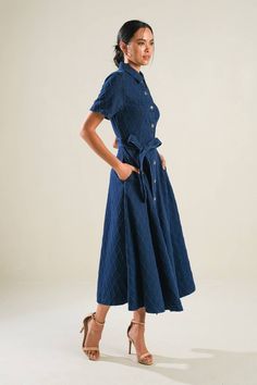 A textured denim midi dress featuring shirt collar, button down, short sleeve, self sash, side pockets and full skirt Details: Self : 100% Cotton Size & Fit - Model is 5`8" And Wearing Size Small- Measurements Taken From Size Small- Approx. Length: 49" Belted Midi Denim Dress In Medium Wash, Short Sleeve Belted Denim Workwear Dress, Belted Medium Wash Dress For Work, Chic Denim Blue Shirt Dress For Work, Belted Denim Dress With Short Sleeves For Work, Denim Blue Workwear Dress With Buttoned Pockets, Denim Blue Short Sleeve Dresses With Pockets, Denim Midi Dress With Short Sleeves For Work, Spring Short Sleeve Belted Denim Dress