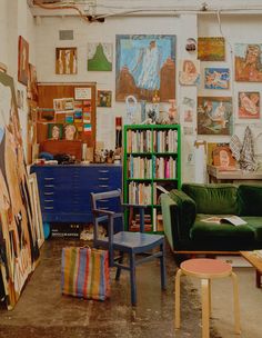 a living room filled with furniture and lots of pictures on the wall next to bookshelves