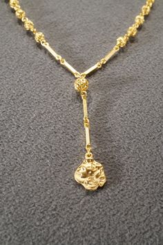 I am offering this fabulous vintage yellow gold tone necklace. This piece is truly gorgeous, and it has the following features: * beautiful vintage necklace * female figural * tassel * dangle * line link * 16 inches in length This is a fantastic and classic piece. There is tons of sparkle and shine with this piece. It will beautifully complement your upcoming fashion season. Buyer pays all shipping and handling. Antique Gold Dangle Necklaces, Vintage Gold Drop Necklace As Gift, Vintage Gold Drop Necklace For Gifts, Antique Gold Lariat Necklace, Art Deco Yellow Gold Dangle Jewelry, Vintage Yellow Gold Double Chain Necklace, Luxury Yellow Gold Art Deco Necklace, Vintage Yellow Dangle Jewelry, Luxury Gold-tone Dangle Necklace