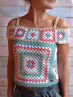 a mannequin wearing a crocheted top with an open shoulder and short sleeves