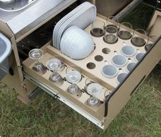 an open drawer in the back of a camper with pots and pans on it