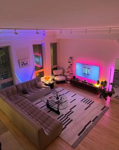 a living room filled with furniture and a flat screen tv sitting on top of a wooden floor