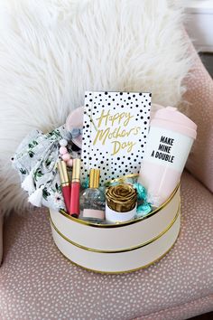 a white and gold gift box filled with makeup, lipstick, coffee cup and other items