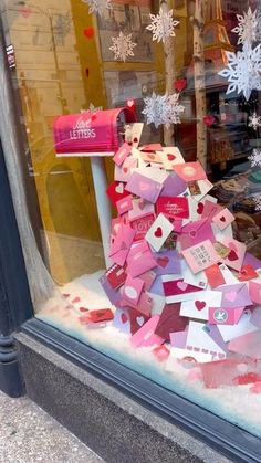 a window display with lots of pink and red boxes on it's windowsill