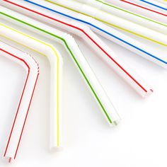 several different colored straws lined up on a white surface