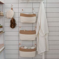 there is a towel rack in the bathroom with baskets on it and towels hanging from hooks