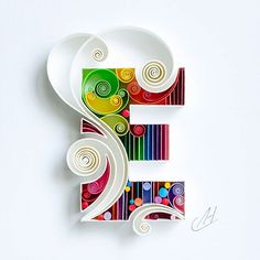 the letter e is made out of paper and decorated with swirls, circles, and spirals