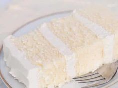 a piece of white cake on a plate with a fork and knife next to it