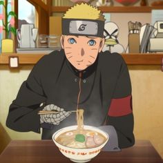 a man sitting at a table in front of a bowl of ramen