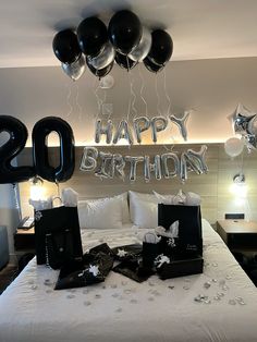 a bed with black and white balloons on top of it