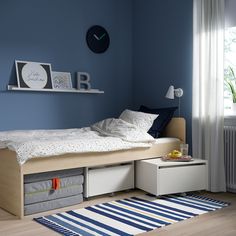 a bedroom with blue walls and white furniture