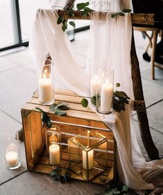 a wooden box with candles and greenery on it