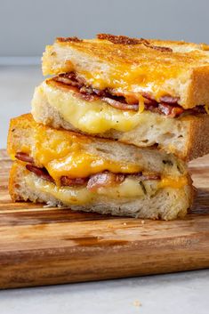 two grilled cheese sandwiches stacked on top of each other with bacon and cheddar