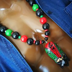 African mask pendant necklace ~ D E T A I L S ~ ~  20mm red, green & black beads ~  22mm black wood beads ~  14mm black wood beads ~  hand carved mask pendant from  .   Kenya ~  length +- 3 1/2" (9cm) ~  the pendant is hand carved and  .   hand painted so it will differ slightly  .   from the picture ~  lobster clasp ~  handmade necklace  ~ LENGTH ~ Choose from drop down menu The necklace length on the  mannequin is 28" ~ S H I P P I N G  ~ Please see the Announcement on our shop Handmade Black Necklaces For Festivals, Handmade Black Necklace For Festivals, Festival Gift Necklace With Black Beads, Traditional Green Necklace With Black Beads, Artisan Black Jewelry For Festivals, Carved Mask, African Necklaces, African Beads Necklace, Mask Necklace