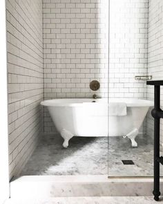 a white bath tub sitting next to a walk in shower