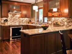 a kitchen with wooden cabinets and marble counter tops, along with an island in the middle