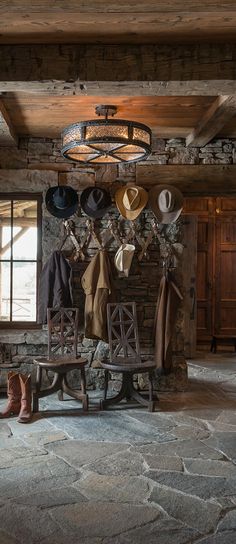 a room with several hats hanging on the wall and two wooden benches in front of it