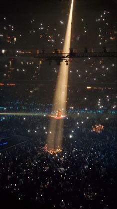 a large group of people in the middle of a stage with lights on it at night