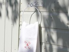 a white towel hanging on the side of a house with a monogrammed initial