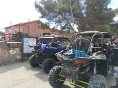 two atvs parked next to each other in front of a building with people looking at them