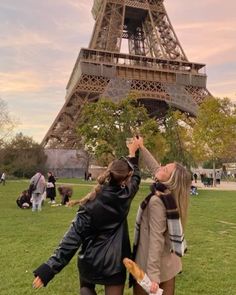 two women standing in front of the eiffel tower