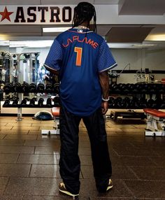 a man with dreadlocks standing in front of a gym