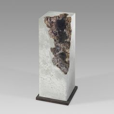 a white and black marble sculpture with a brown base on a gray background, it is in the shape of a rectangle