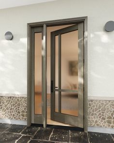 an open glass door on the outside of a building with stone walls and flooring