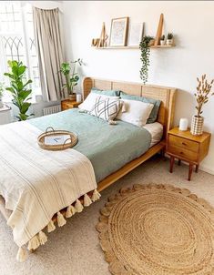 a bedroom with a bed, nightstands and potted plants