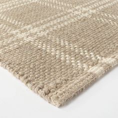 an area rug with white and beige colors on top of the carpet, it is made out of thick yarn