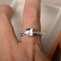 a woman's hand with a ring on it and a white diamond in the middle