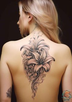 a woman's back tattoo with flowers on it