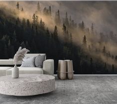 a living room with a couch and table in front of a wall mural that has trees on it