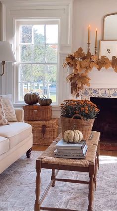 a living room filled with furniture and a fire place covered in pumpkins on the mantle