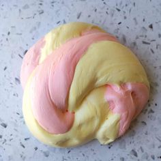 a doughnut with pink and yellow icing on it's side sitting on a table