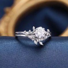 a close up view of a diamond ring on a blue cloth with a gold frame in the background