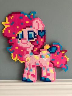 a pink pony made out of legos sitting on top of a shelf