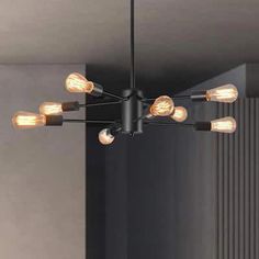 a black chandelier with eight lights hanging from it's sides in a room