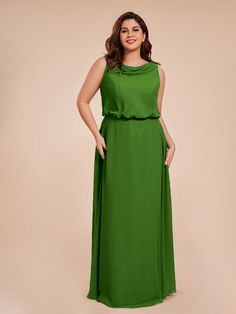 a woman in a green dress posing for the camera with her hands on her hips