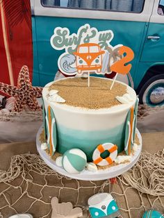 there is a cake with an orange and white car on it, surrounded by beach decorations