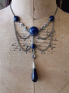 Featuring an absolutely gorgeous antique c.1900s Bohemian Arts and Crafts Jugendstil Art Nouveau solid sterling silver ornate festoon necklace adorned with beautiful marbled Sodalite stones set in open back settings.  Necklace measures approximately 16 inches around with a 3 inch pendant drop at 28.2 grams respectively.  This rare turn of the century festoon is in excellent antique condition with a functional antique thumbless clasp, a beautiful patina with all stones intact and accounted for.  Stamped STERLING on the reverse of center stone, don't miss this gorgeous beautifully handcrafted antique necklace! Please feel free to contact me with any questions or suggestions I'm always learning (Box not included) Victorian Silver Necklace With Historical Design, Antique Silver Necklace With Historical Design, Victorian Antique Silver Necklace With Intricate Design, Victorian Silver Necklace With Antique Finish, Handmade Antique Silver Victorian Necklace, Handmade Victorian Antique Silver Necklaces, Handmade Victorian Antique Silver Necklace, Vintage Blue Ceremonial Jewelry, Victorian Round Necklace With Antique Finish