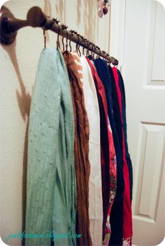 clothes hanging on a rack in front of a door