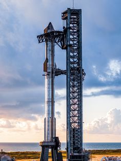 a large metal structure sitting next to the ocean