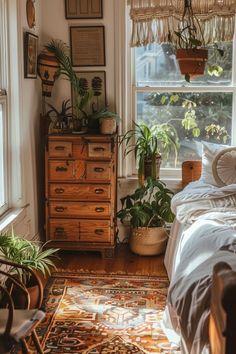 a bed room with a neatly made bed and lots of plants on the windowsill