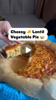 a person holding a piece of cheese pizza in their hand with the caption cheesy lentil vegetable pie