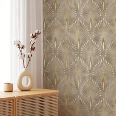 a vase with flowers on top of a wooden dresser next to a window in a room