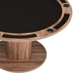 a round wooden table with black glass top