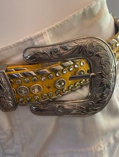 Vintage Kippy's leather belt with Swarovski crystals is a standout accessory that combines the rugged appeal of high-quality leather with the luxurious sparkle of Swarovski crystals, making it a unique and stylish addition to any wardrobe. This belt can be worn with jeans for a casual, Western-inspired look or paired with a dress to add a touch of edgy glamour. The belt features a large, ornate buckle,  crafted from metal and the unique yellow leather is very eye-catching with the silver and crystals combination. Excellent condition Size  Length 34" Width 1 1/2" Buckle Size 3 1/2" x 3 1/2" Crystals Combination, Yellow Leather, High Quality Leather, Leather Belt, A Dress, Swarovski Crystals, Belts, Accessory Gift, Buckle