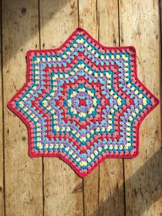 a crocheted doily is laying on a wooden surface