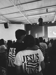 a group of people standing in front of a projector screen with jesus king on it